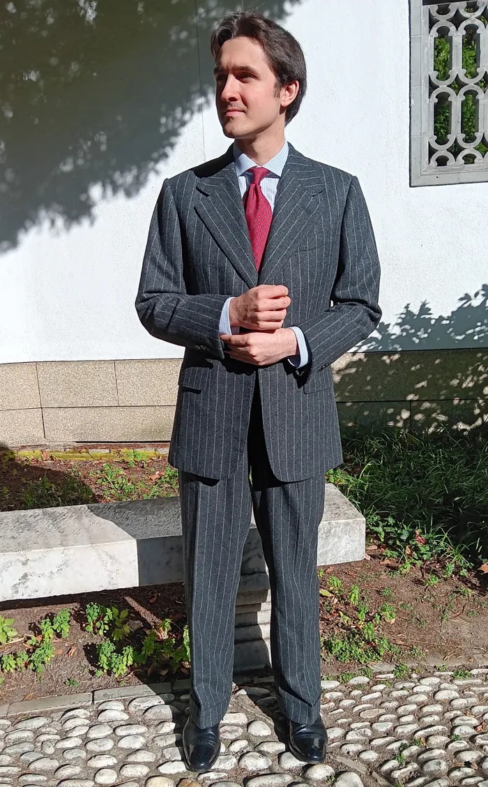 Client in a grey pinstripe suit outside a stone building
