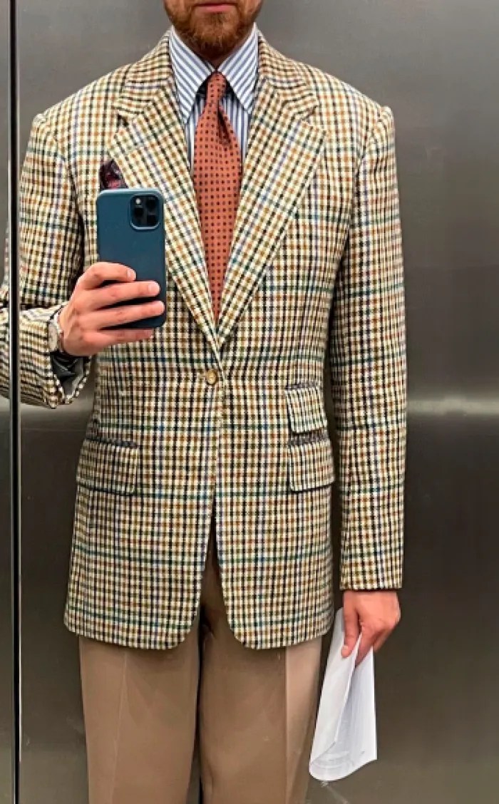 Client photographing his checked jacket in a mirror