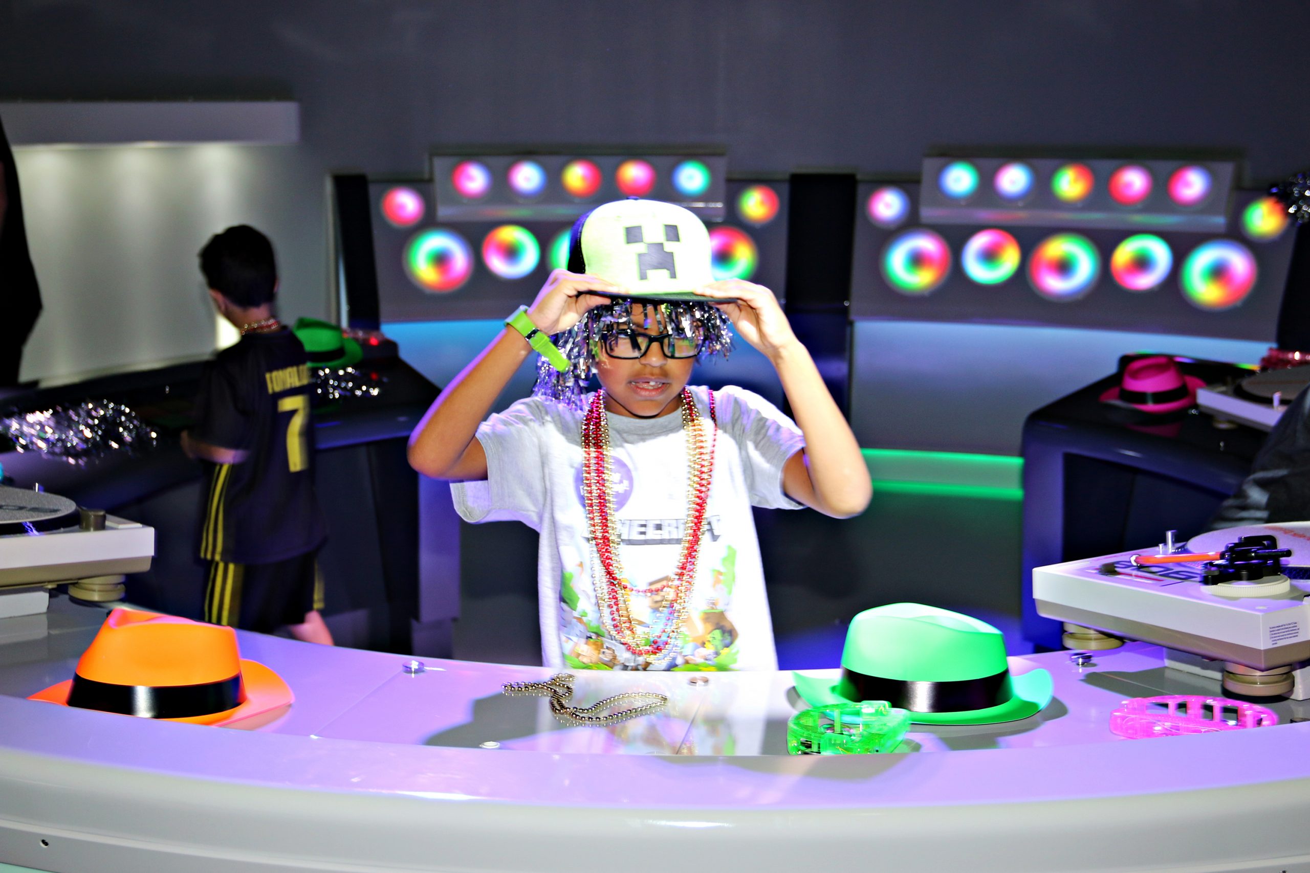 A boy holds onto his Minecraft hat and listens to music, as he enjoys his birthday party at Kefi - an indoor play space for kids in Buckhead Atlanta.