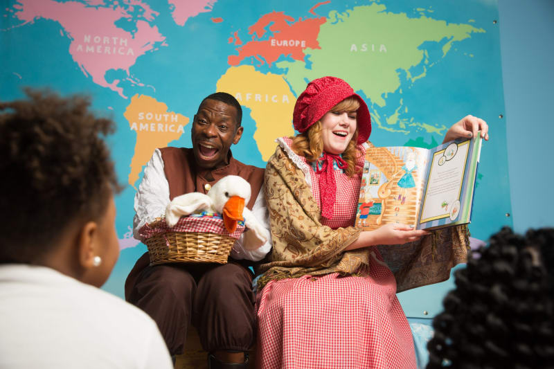 Two animated adults telling a story to children at the Children's Museum of Atlanta.