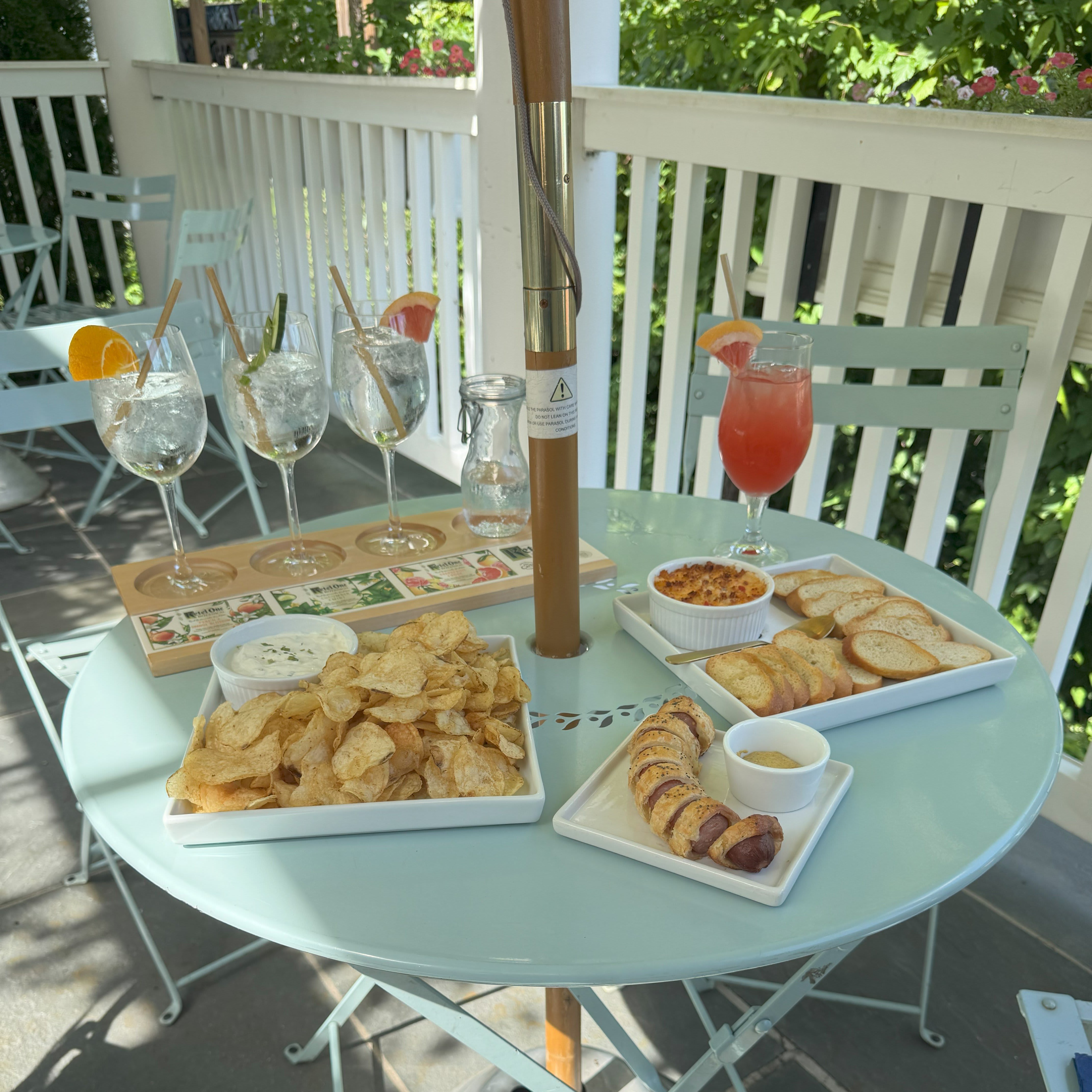Tour Atlanta Beltline From Krog Street Market to Ponce City Market 8 A round blue table on a porch with food and drinks, including chips, dips, and colorful cocktails in Atlanta, Georgia.