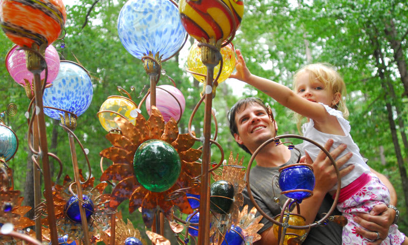 Father and daughter get a closer look of an artist's work at the Yellow Daisy Festival in Stone Mountain Atlanta.