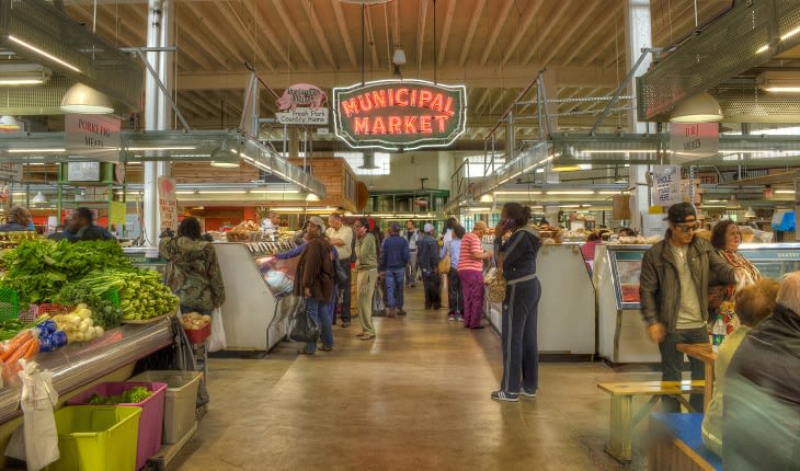 A bustling indoor market filled with fresh produce, meats, and people shopping in Atlanta, Georgia.