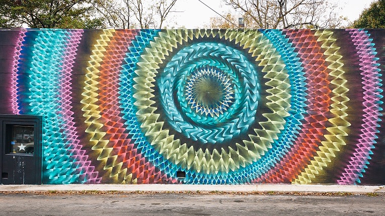A vibrant, colorful mural of concentric circles adorns a wall in Atlanta, Georgia.