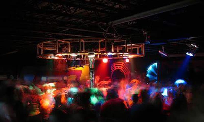 A crowded nightclub with vibrant, colorful lights and a lively atmosphere in Atlanta, Georgia.