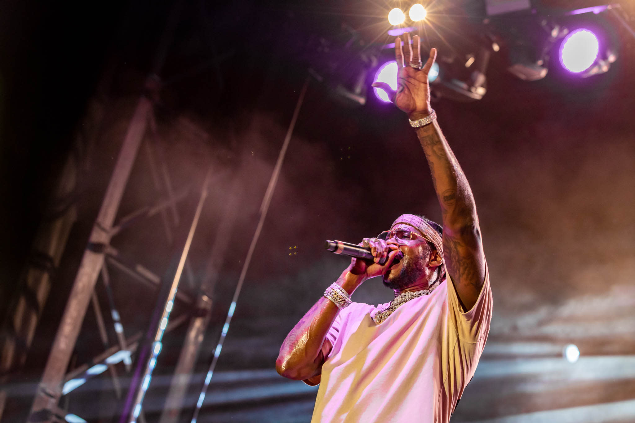 A performer passionately sings into a microphone on stage, bathed in colorful lights in Atlanta, Georgia.