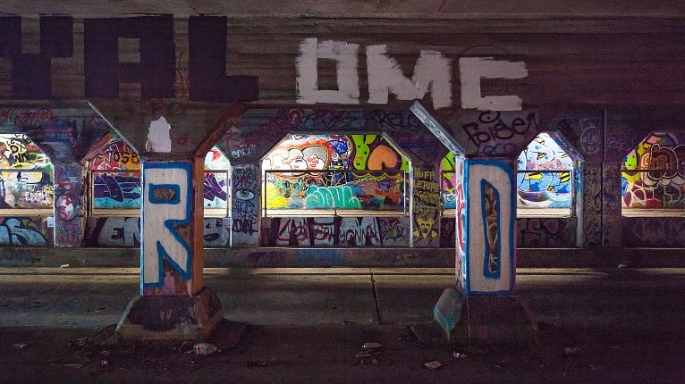 Colorful graffiti covers concrete pillars and walls in an urban underpass in Atlanta, Georgia.