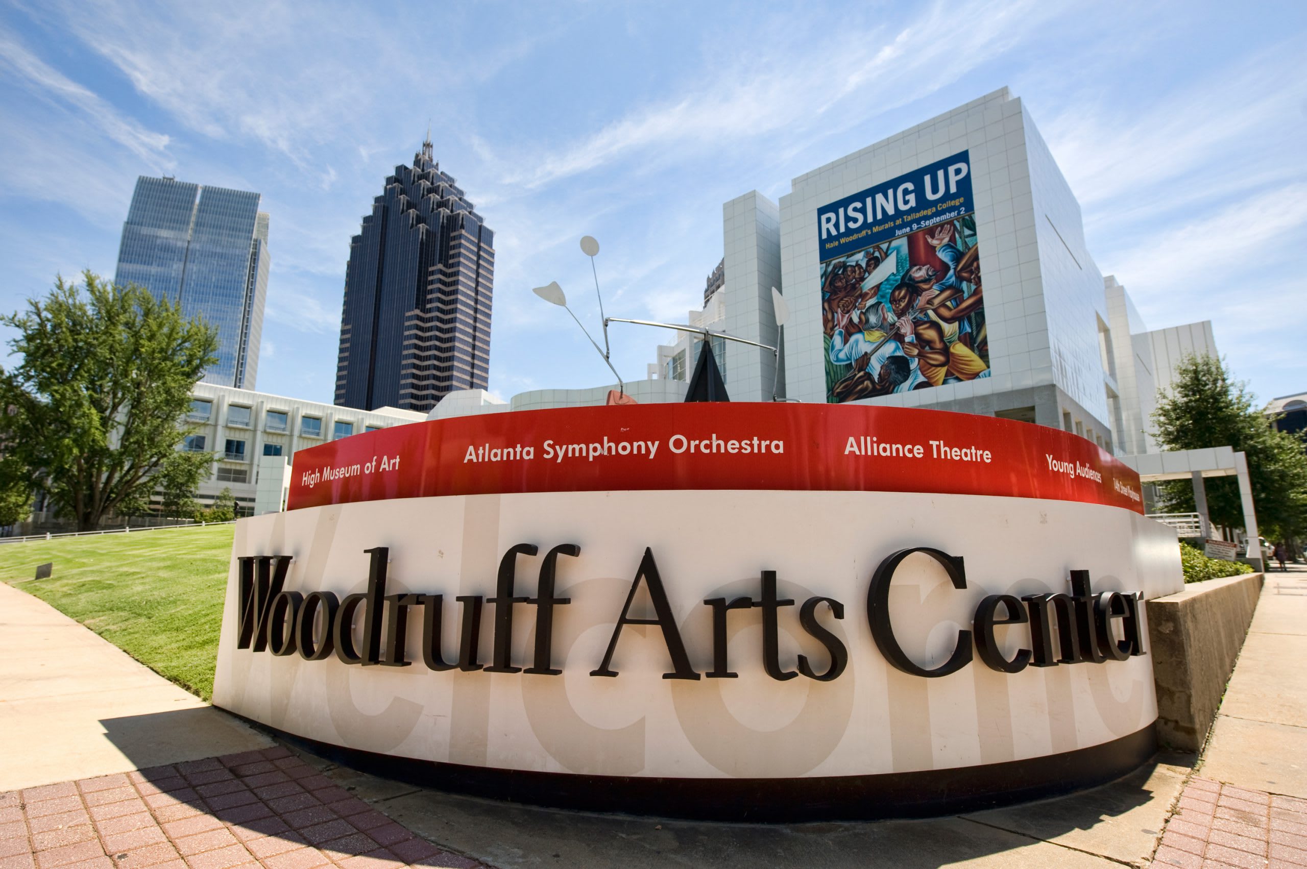 A modern arts center with a large sign, surrounded by trees and tall buildings in Atlanta, Georgia.