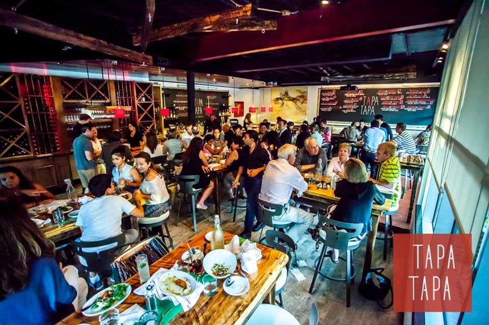 A lively restaurant scene with patrons dining and socializing at wooden tables in Atlanta, Georgia.