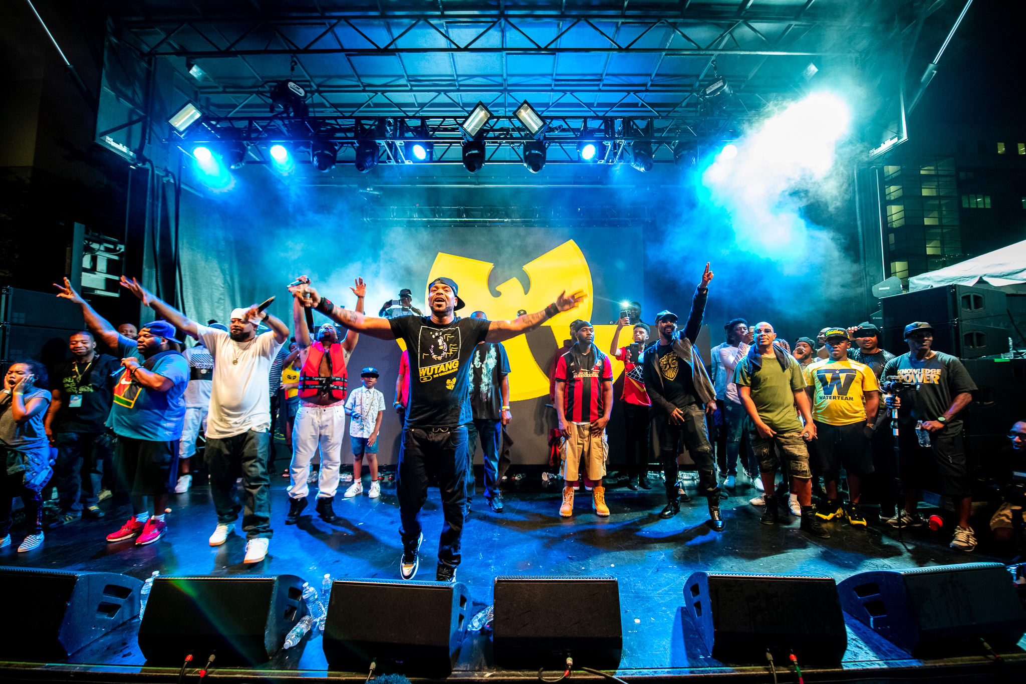 A large group of people perform on stage with a yellow W logo backdrop in Atlanta, Georgia.