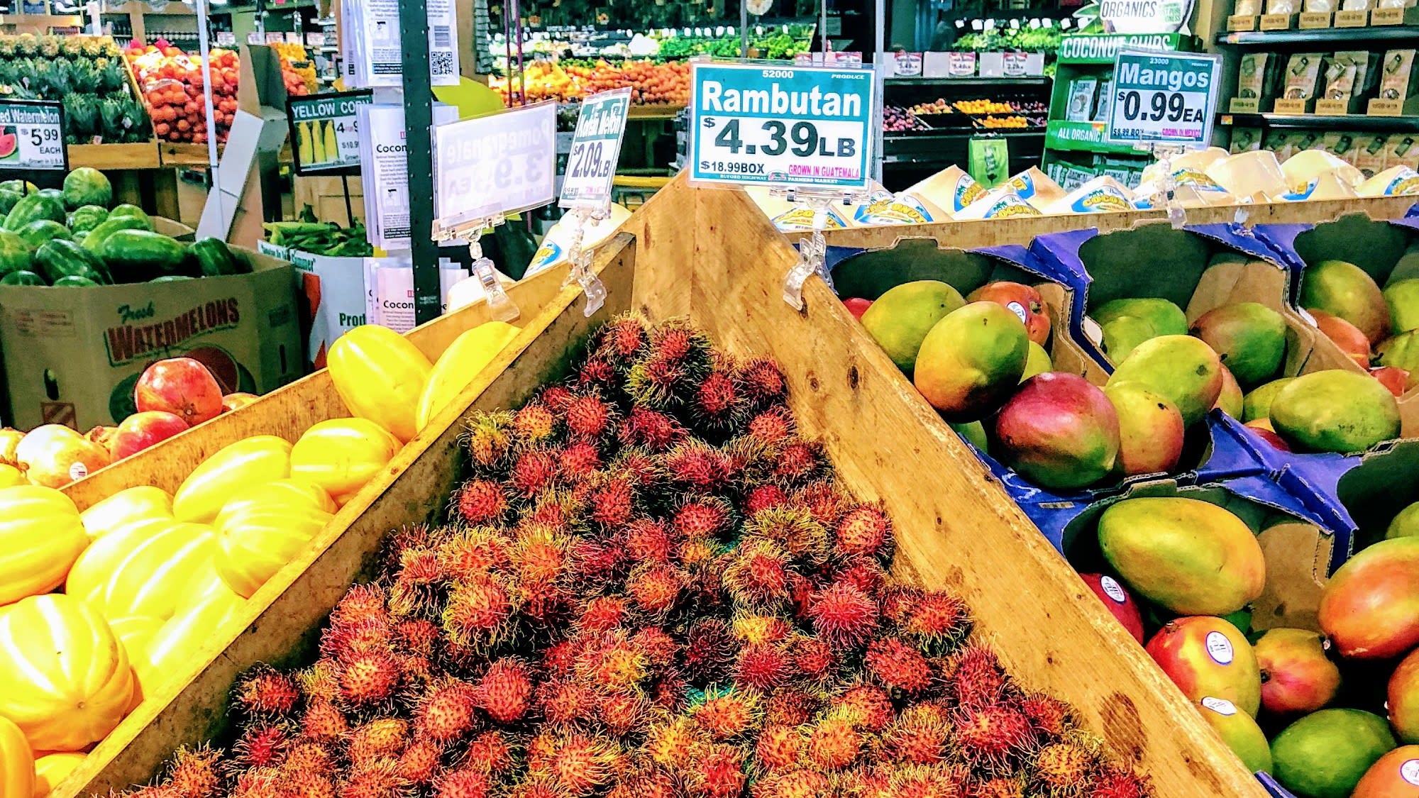 A vibrant fruit display featuring colorful tropical fruits like rambutan, mangoes, and watermelons in Atlanta, Georgia.