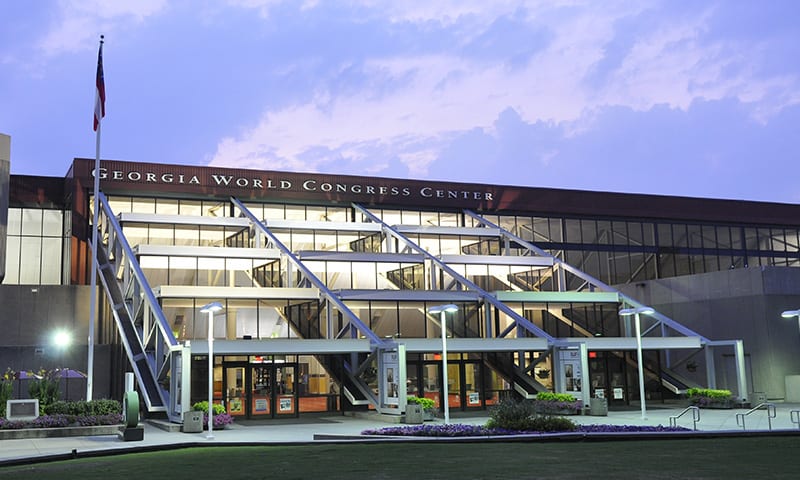 A modern glass building with a geometric design and an American flag flying outside in Atlanta, Georgia.
