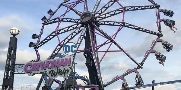A vibrant Ferris wheel with suspended cars spins high in the sky at an amusement park in Atlanta, Georgia.