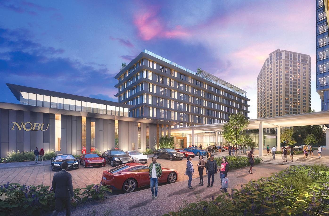 Modern urban complex with glass-fronted buildings, parking lot, and people walking at dusk in Atlanta, Georgia.