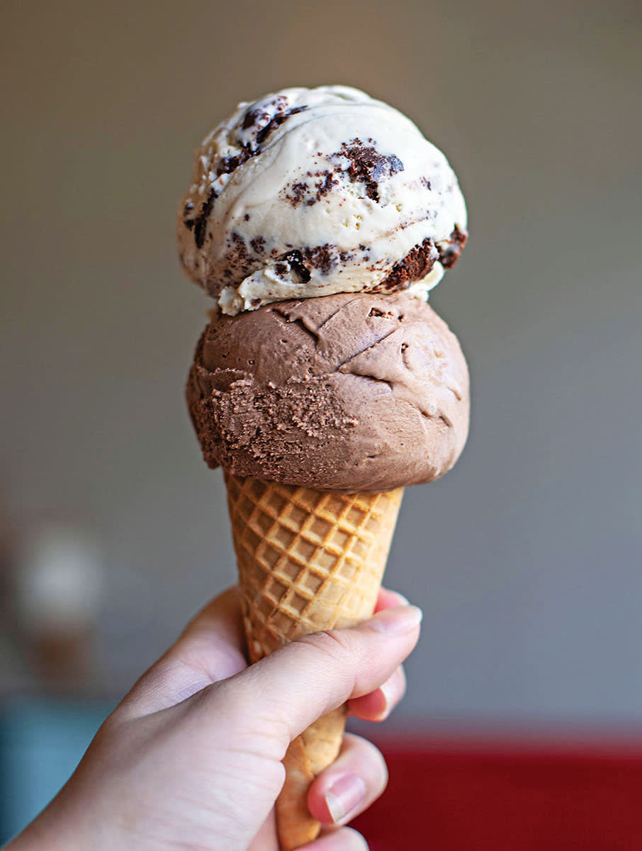 A hand holds a tall ice cream cone with two scoops: chocolate chip and chocolate in Atlanta, Georgia.