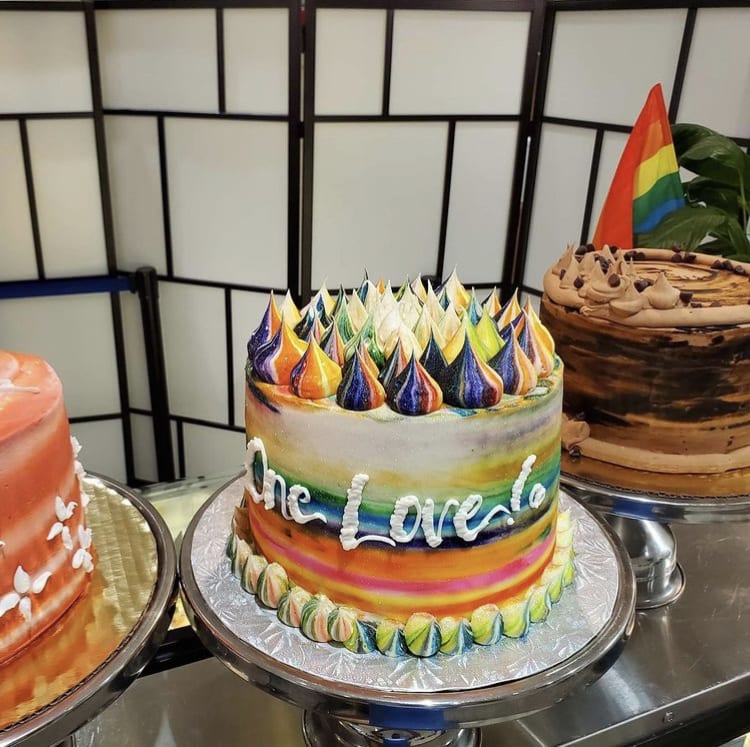 Three beautifully decorated cakes on display, including a colorful 'One Love' cake in Atlanta, Georgia.