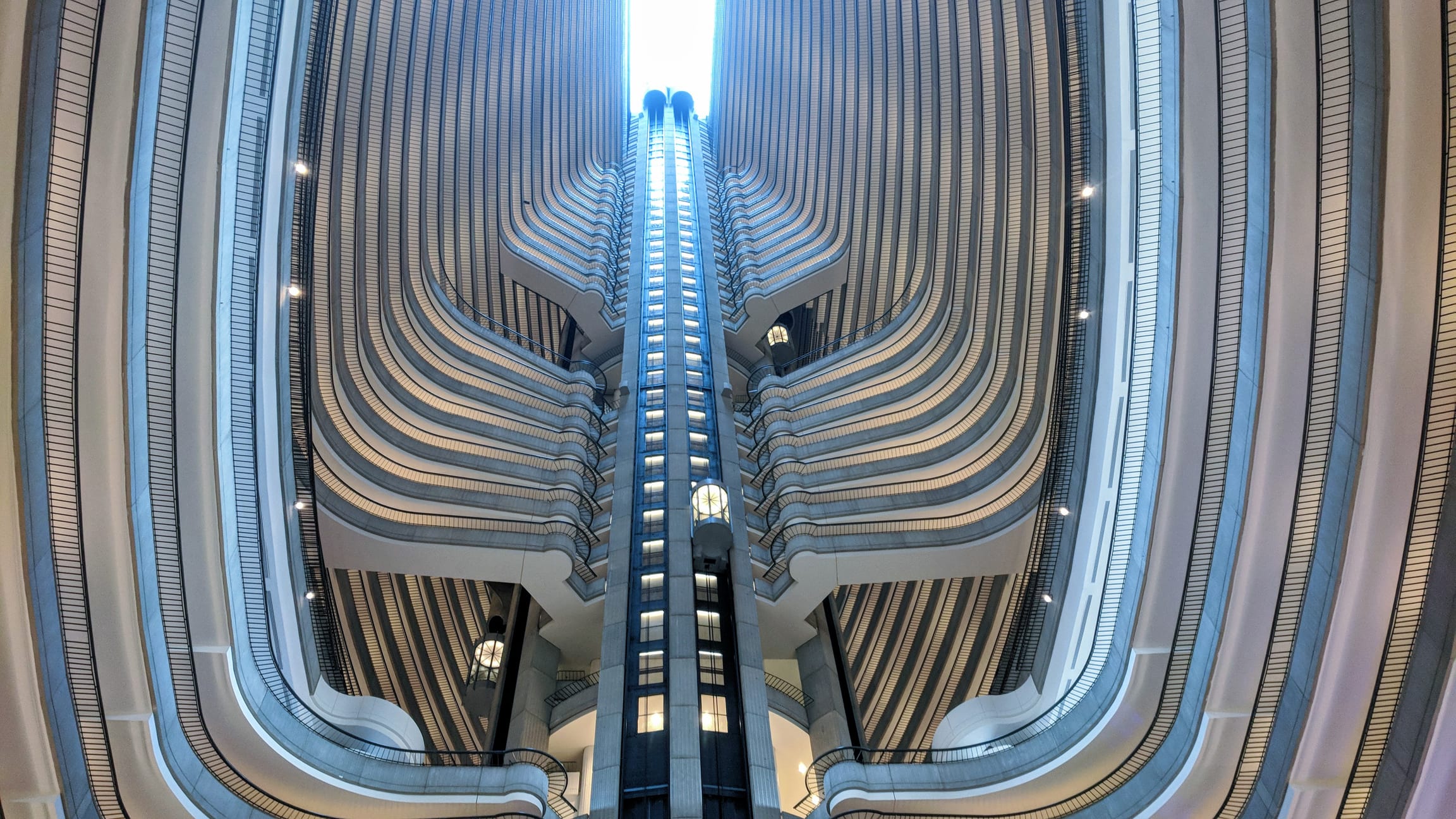 A towering atrium with a central glass shaft and curved balconies on multiple levels in Atlanta, Georgia.
