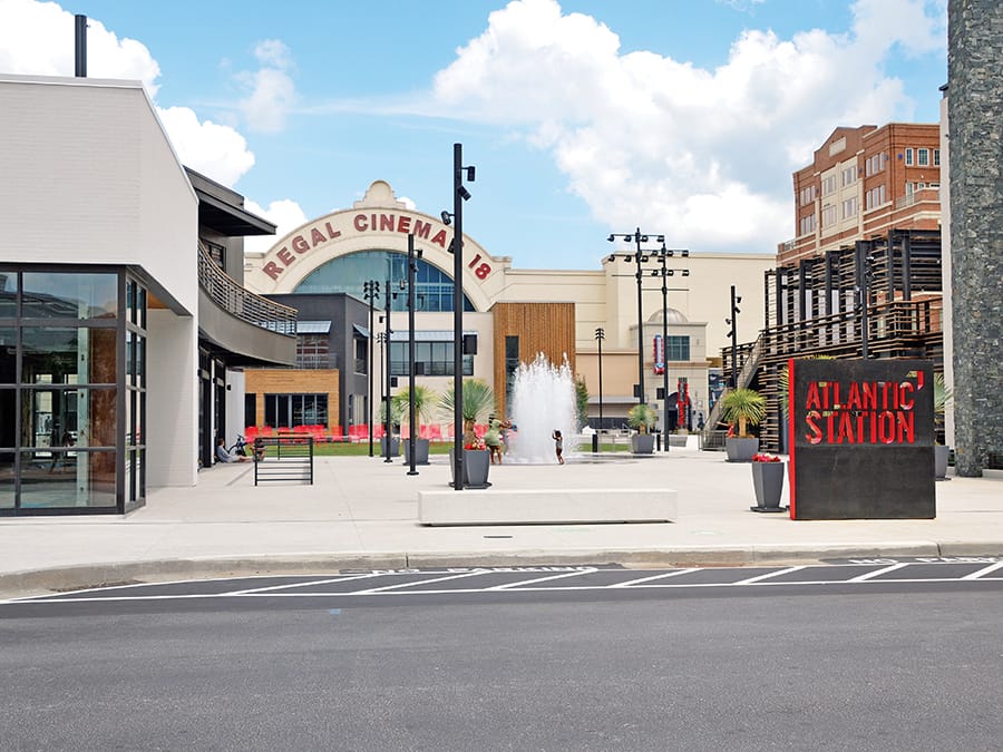 Modern outdoor plaza with fountain, movie theater, and restaurant signage in Atlanta, Georgia.