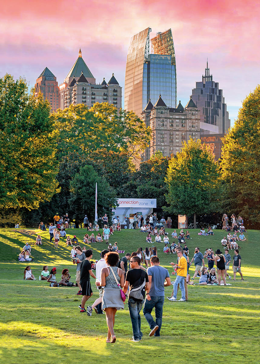 A vibrant city park at sunset with people enjoying the grass and skyline view in Atlanta, Georgia.