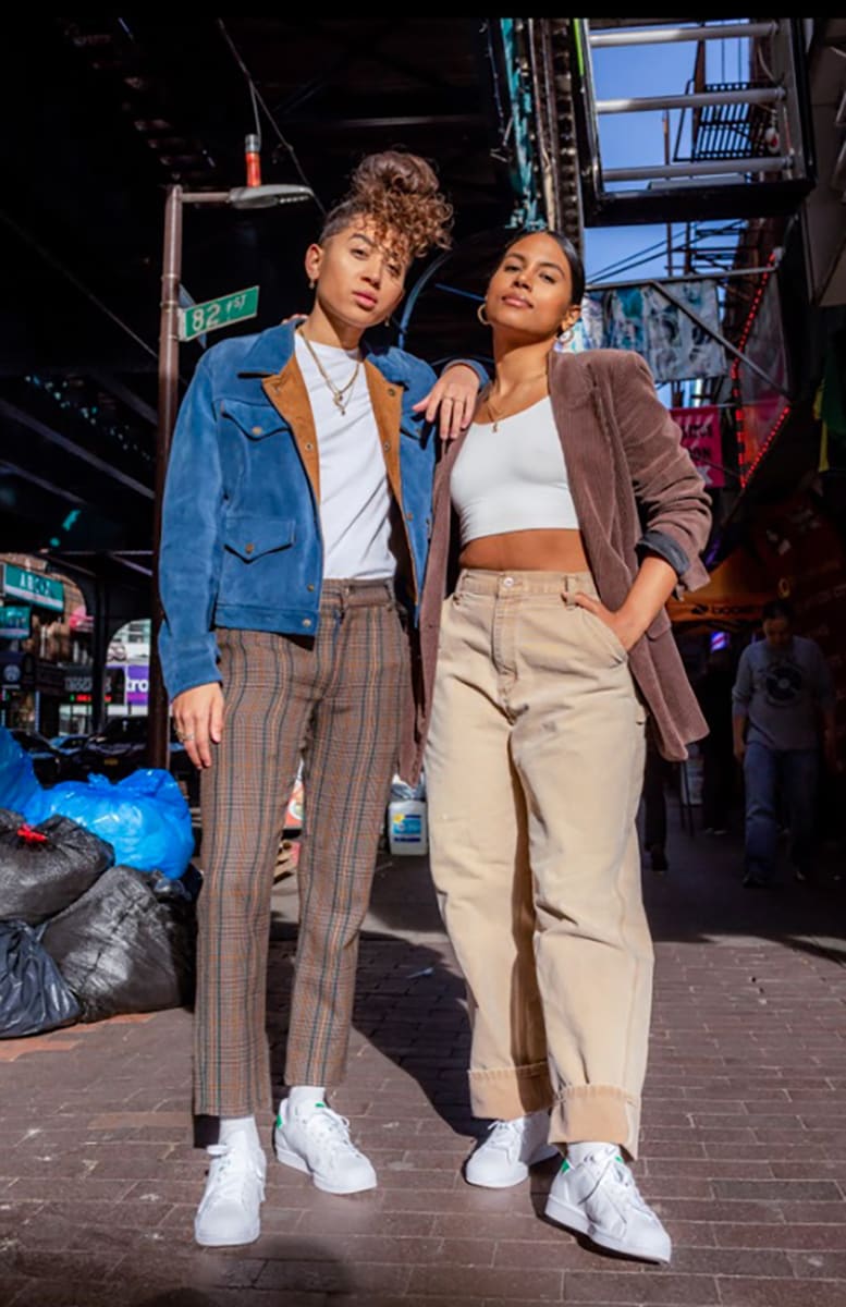 Two young women pose confidently on a city street, showcasing their stylish outfits in Atlanta, Georgia.