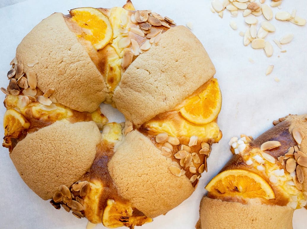 Two orange-flavored pastries with almond slices, resembling bagels or doughnuts in Atlanta, Georgia.