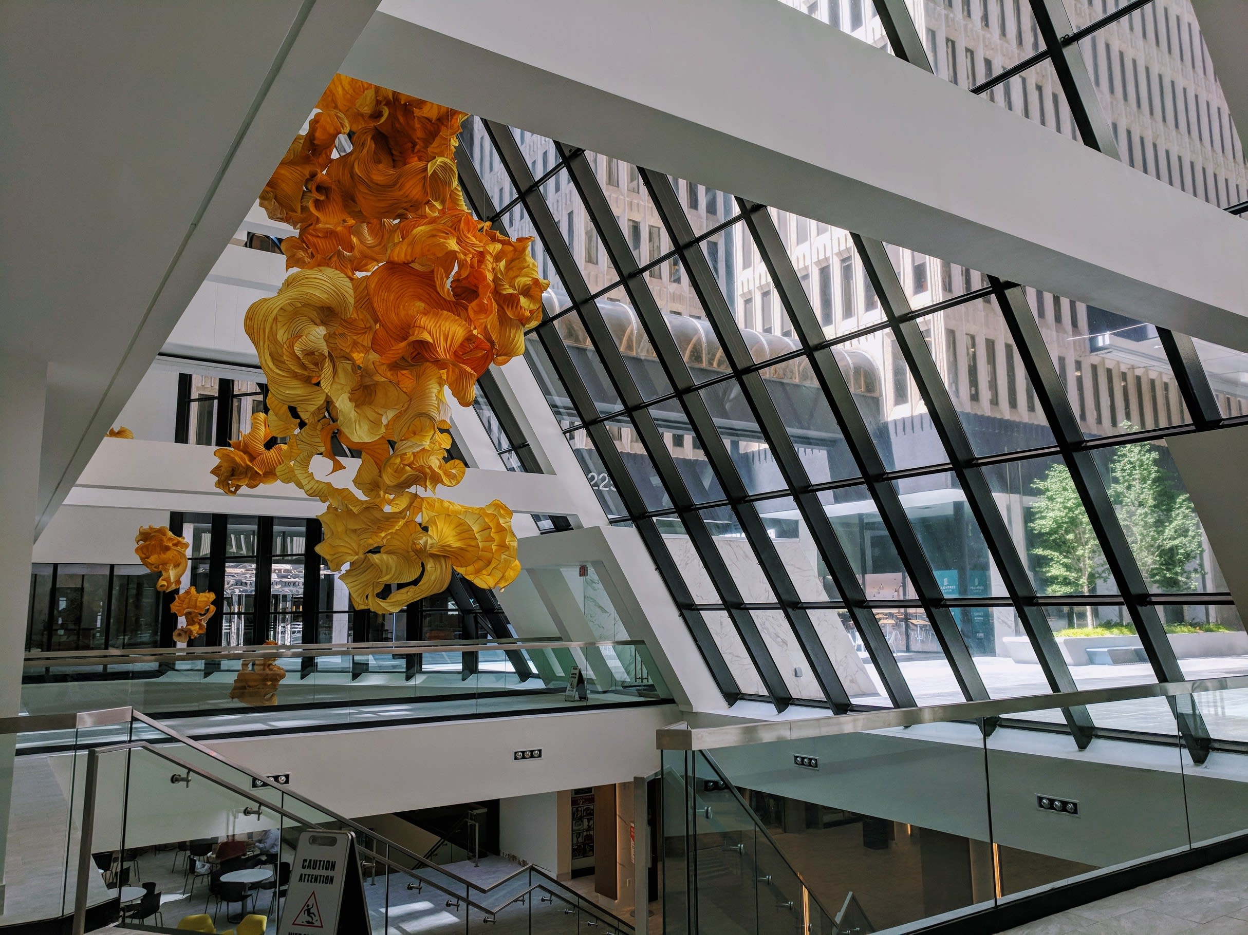 Modern building interior with large glass windows and yellow hanging sculptures in Atlanta, Georgia.