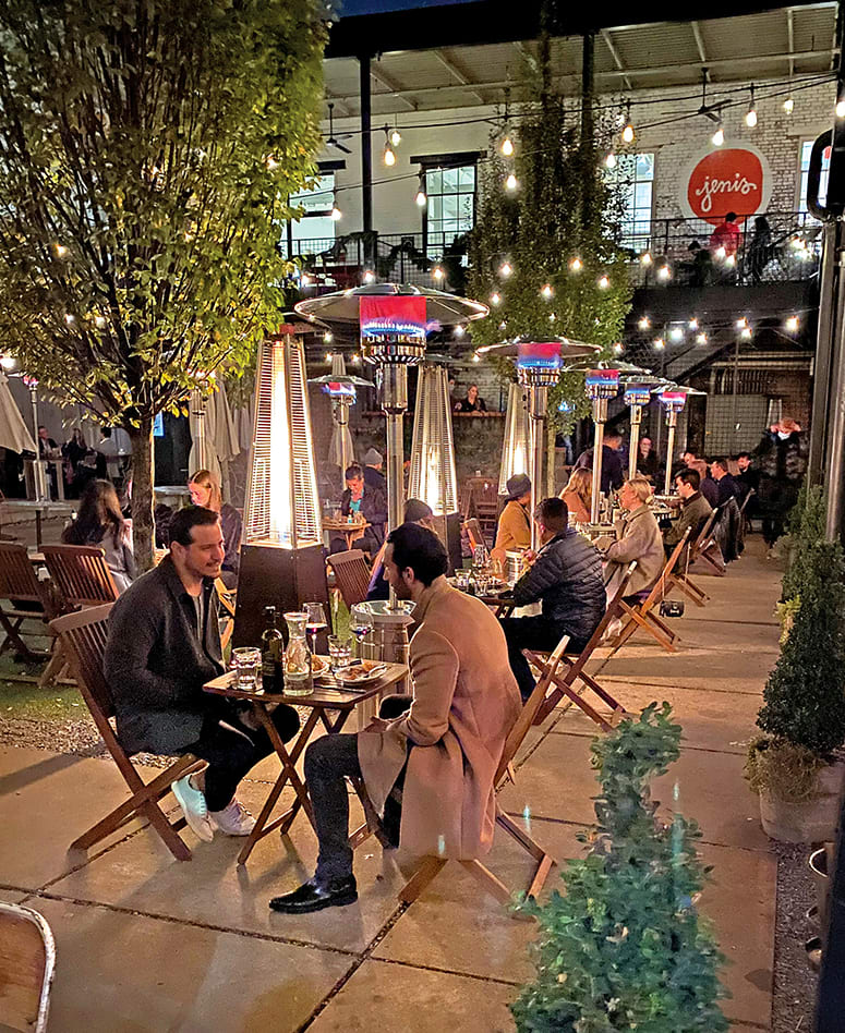Outdoor restaurant patio with heated patio heaters, tables, chairs, and string lights in Atlanta, Georgia.