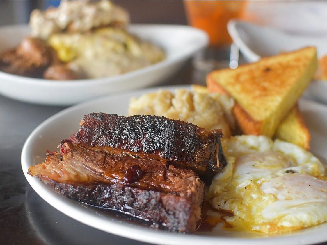 A hearty breakfast plate with grilled steak, sunny-side-up eggs, and toast in Atlanta, Georgia.