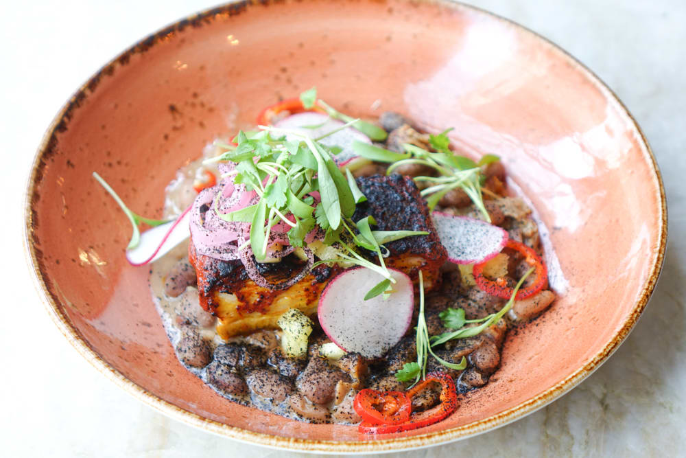 A colorful bowl of food with grilled meat, beans, vegetables, and microgreens in Atlanta, Georgia.