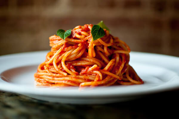 A plate of spaghetti covered in tomato sauce with fresh basil leaves on top in Atlanta, Georgia.