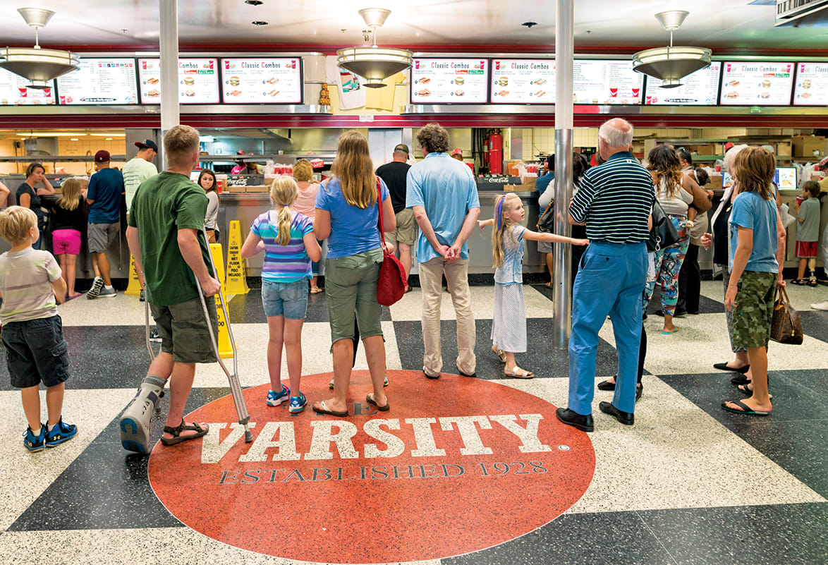 Crowded diner with checkered floor, menu boards, and customers waiting in line in Atlanta, Georgia.