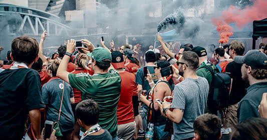 Crowd of people in a stadium, many wearing red, cheering and holding up phones in Atlanta, Georgia.