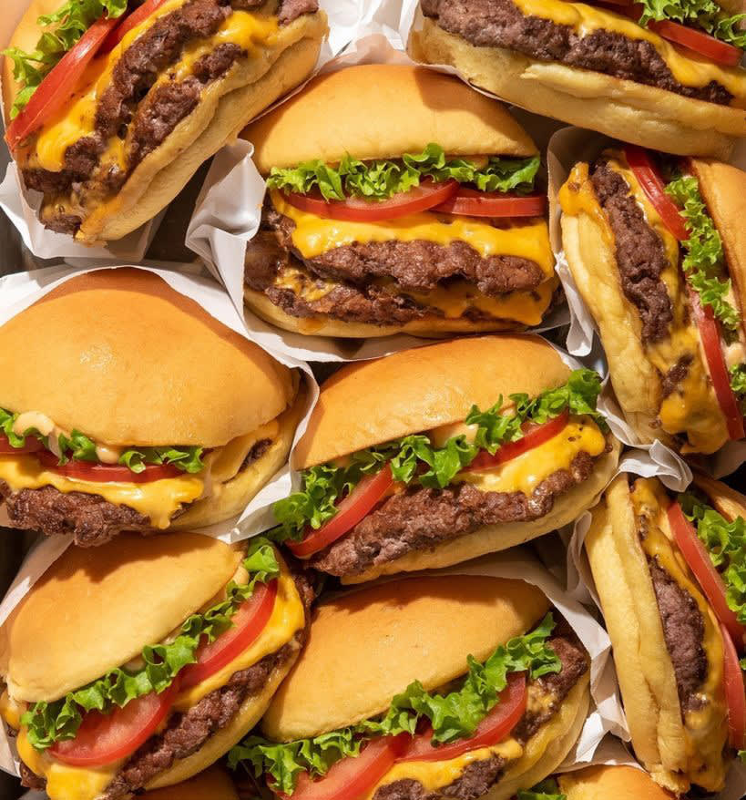 A pile of mouthwatering cheeseburgers with lettuce, tomato, and melted cheese in Atlanta, Georgia.