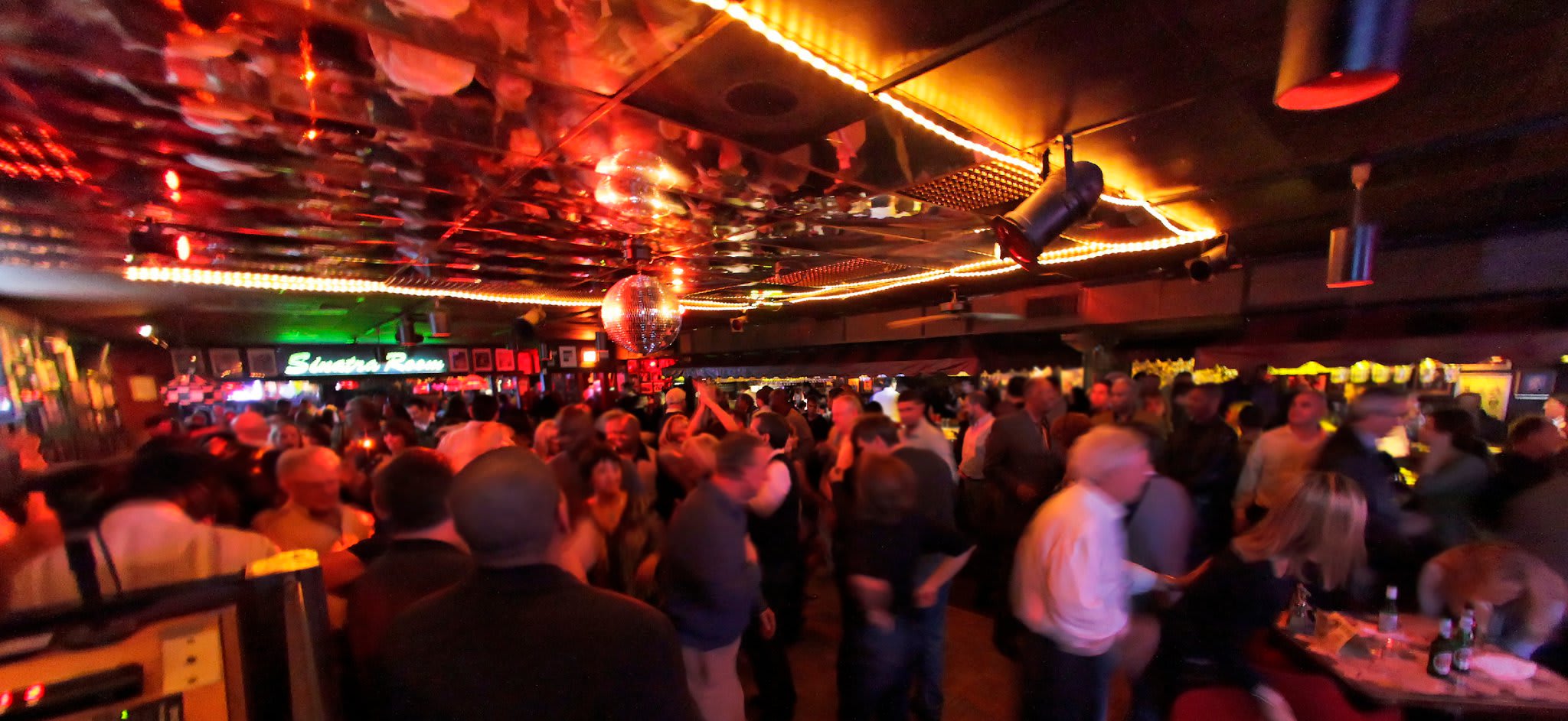 A crowded, dimly lit nightclub with a disco ball and neon lights in Atlanta, Georgia.