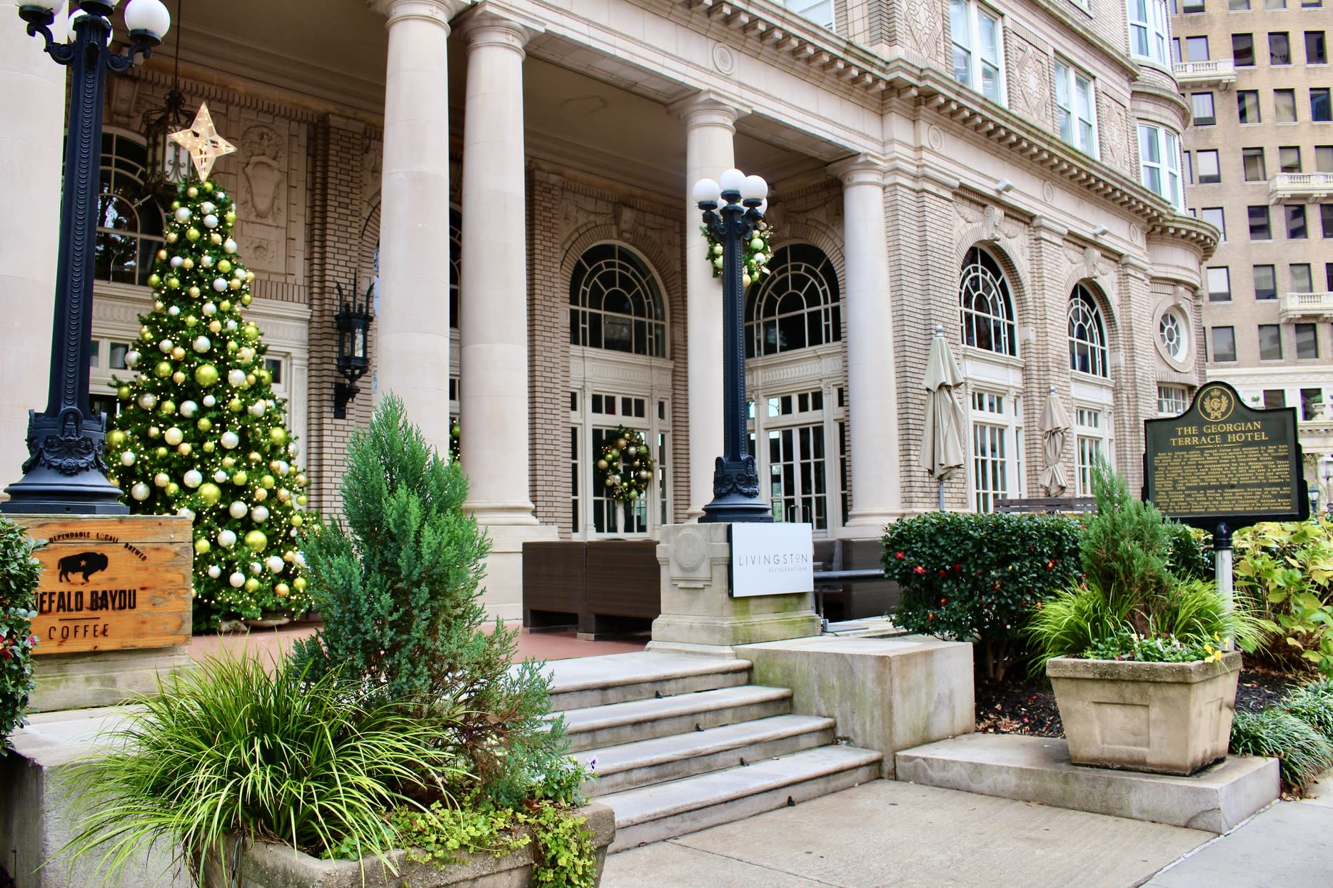 A grand building with columns, decorated for Christmas with a large tree and wreaths in Atlanta, Georgia.