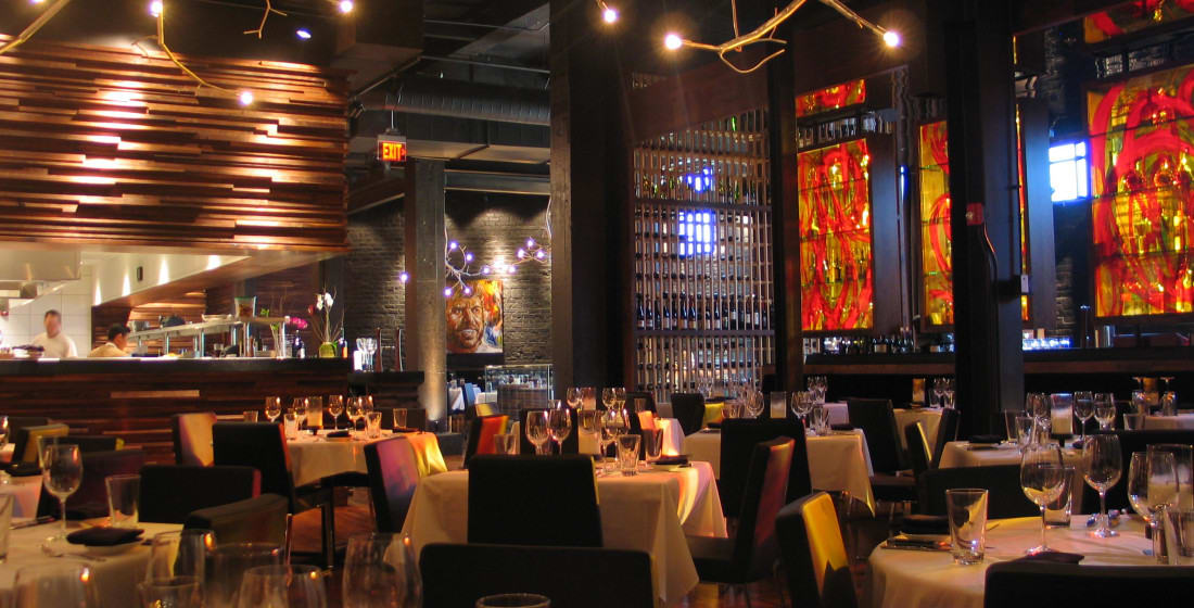 A modern restaurant interior with a bar, wine racks, and tables set for dining in Atlanta, Georgia.