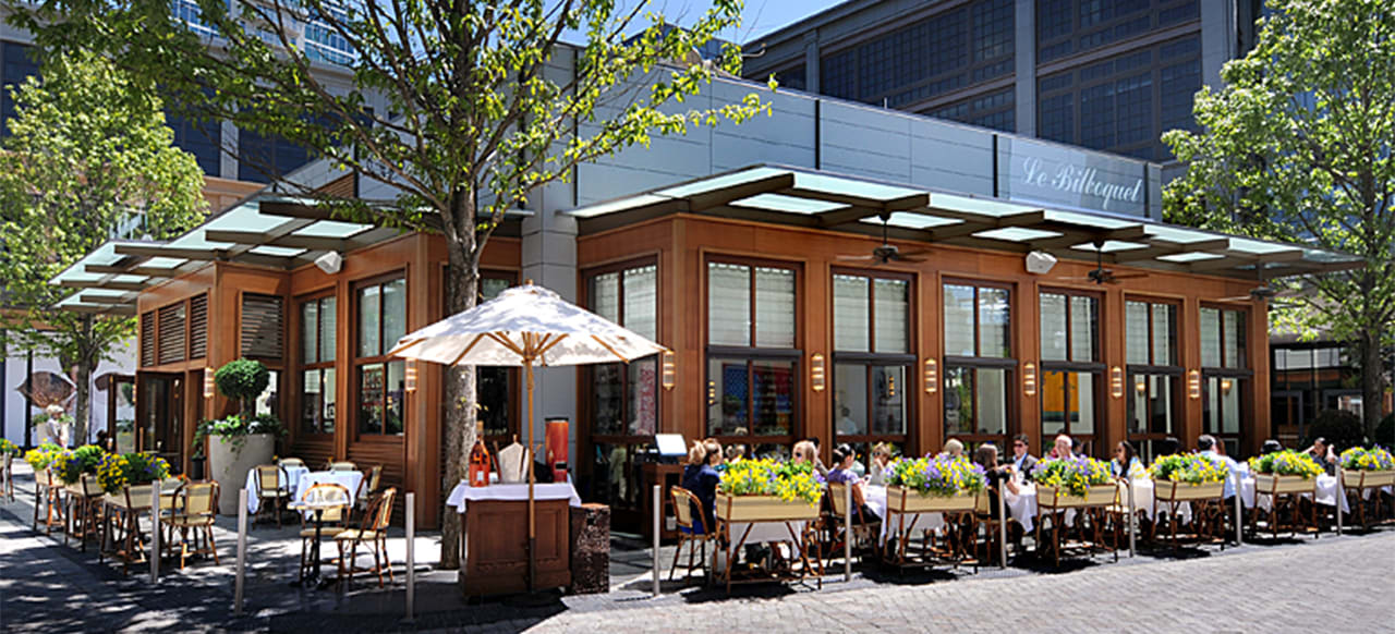 Outdoor seating area of a modern restaurant with wooden walls and glass windows in Atlanta, Georgia.