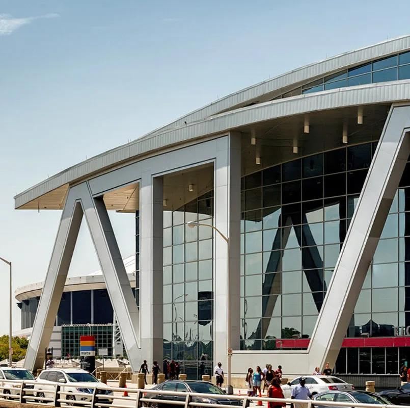 Ultimate Guide to Atlanta Stadium Dining 2 Modern glass building with geometric design and people walking nearby in Atlanta, Georgia.