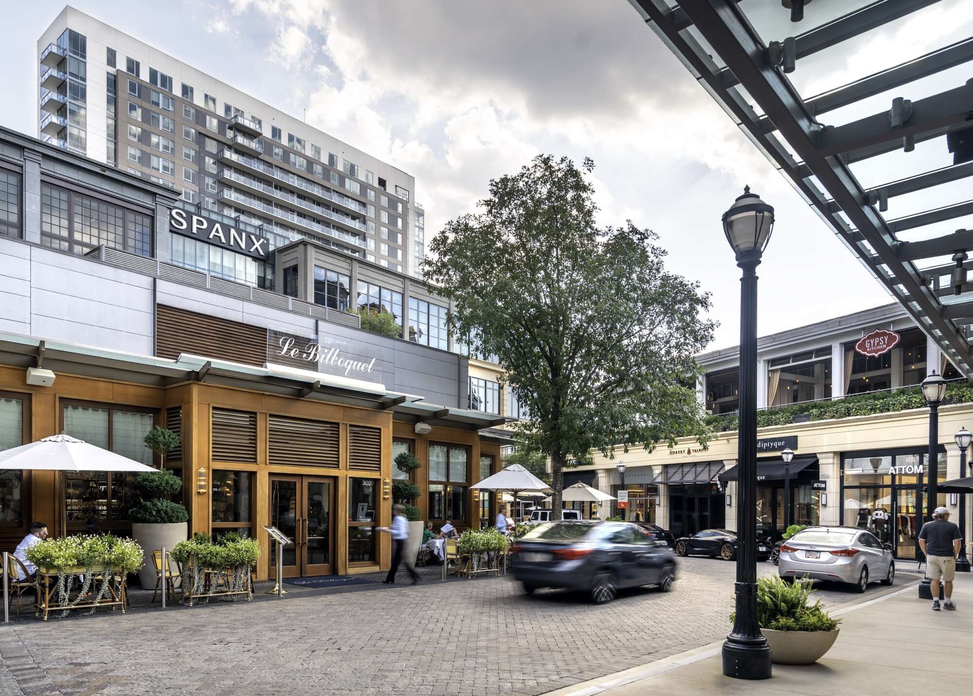 A bustling urban street scene with outdoor cafes, pedestrians, and modern buildings in Atlanta, Georgia.
