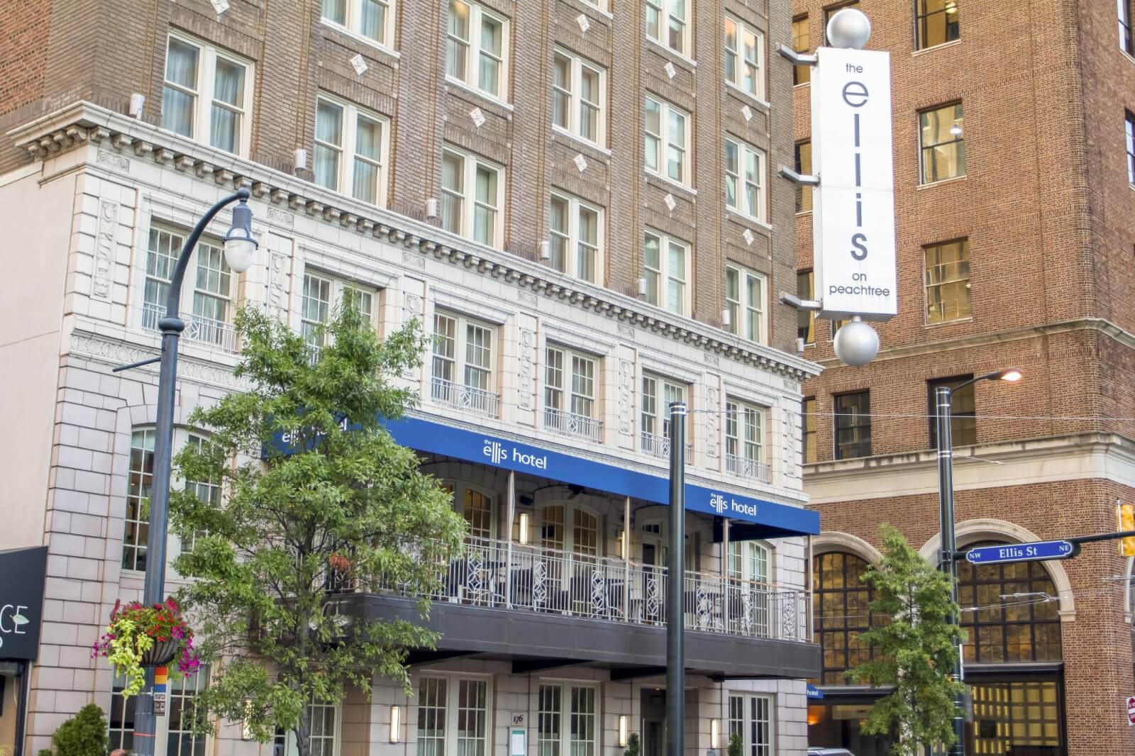 A multi-story hotel with blue awnings and a sign reading 'The Ellis Hotel on Peachtree' is visible in Atlanta, Georgia.