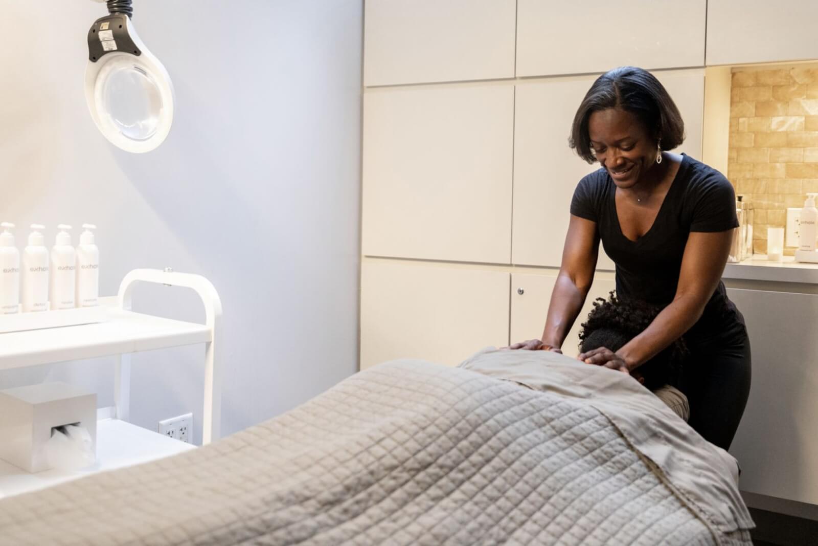A woman receives a massage in a spa-like setting with a practitioner standing over her in Atlanta, Georgia.