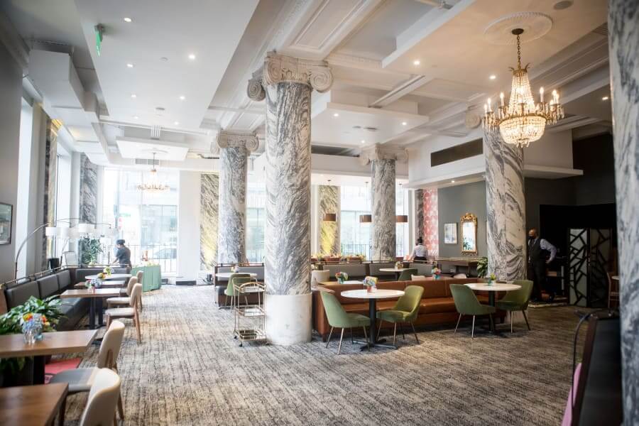 A spacious, elegant restaurant with marble columns, chandeliers, and a variety of seating areas in Atlanta, Georgia.