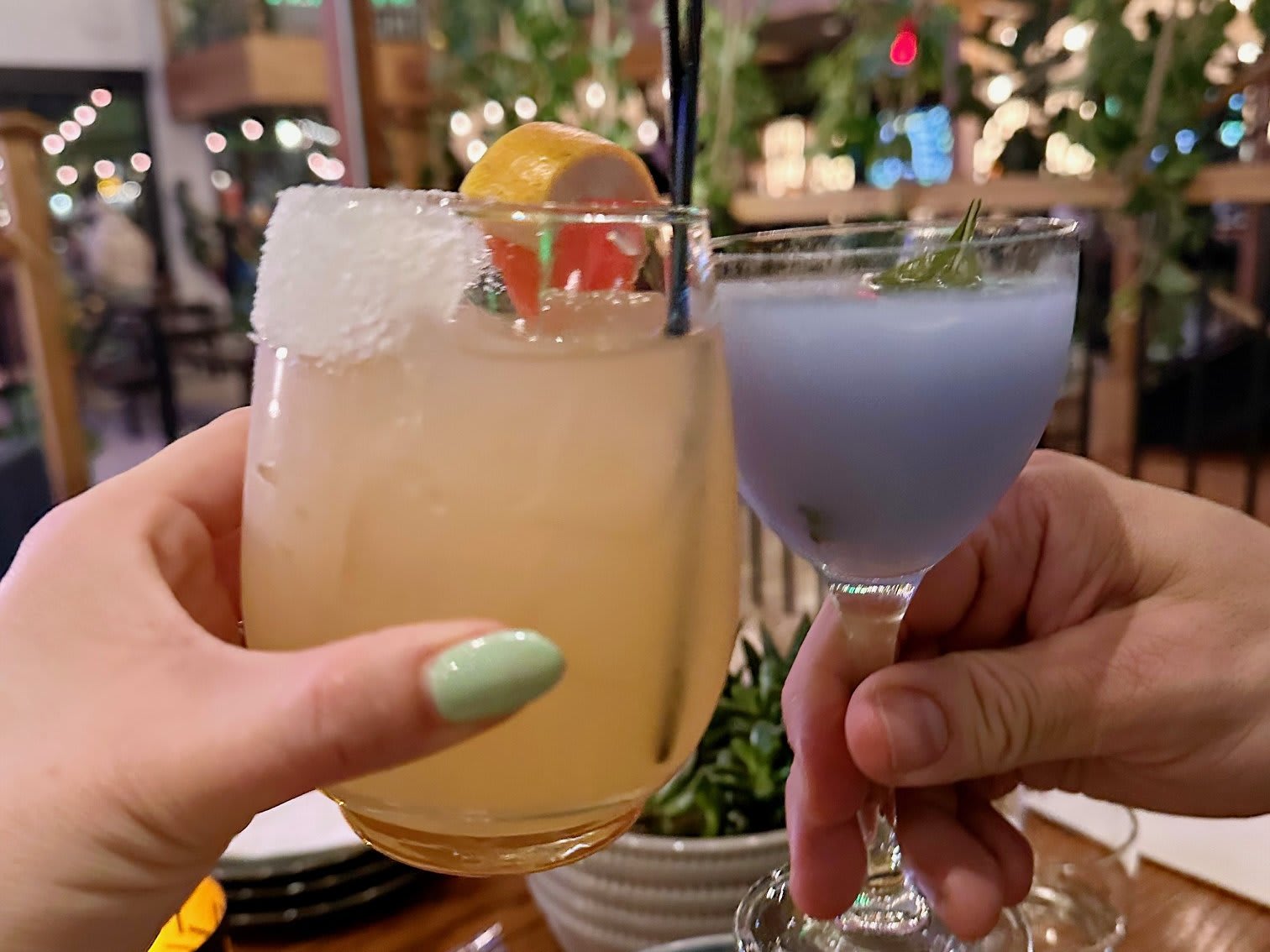 A couple doing a cheers with craft cocktails at Your 3rd Spot in Atlanta.
