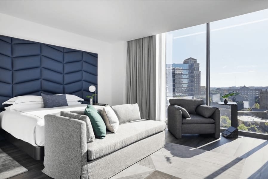 Modern hotel room with floor-to-ceiling windows overlooking a cityscape in Atlanta, Georgia.
