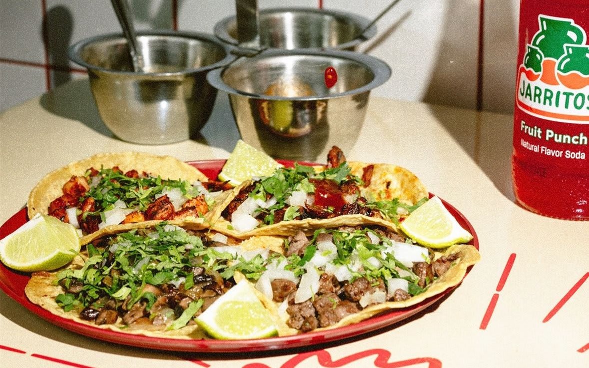 Colorful plate of four tacos with lime wedges, salsa, and a Jarritos soda bottle in Atlanta, Georgia.