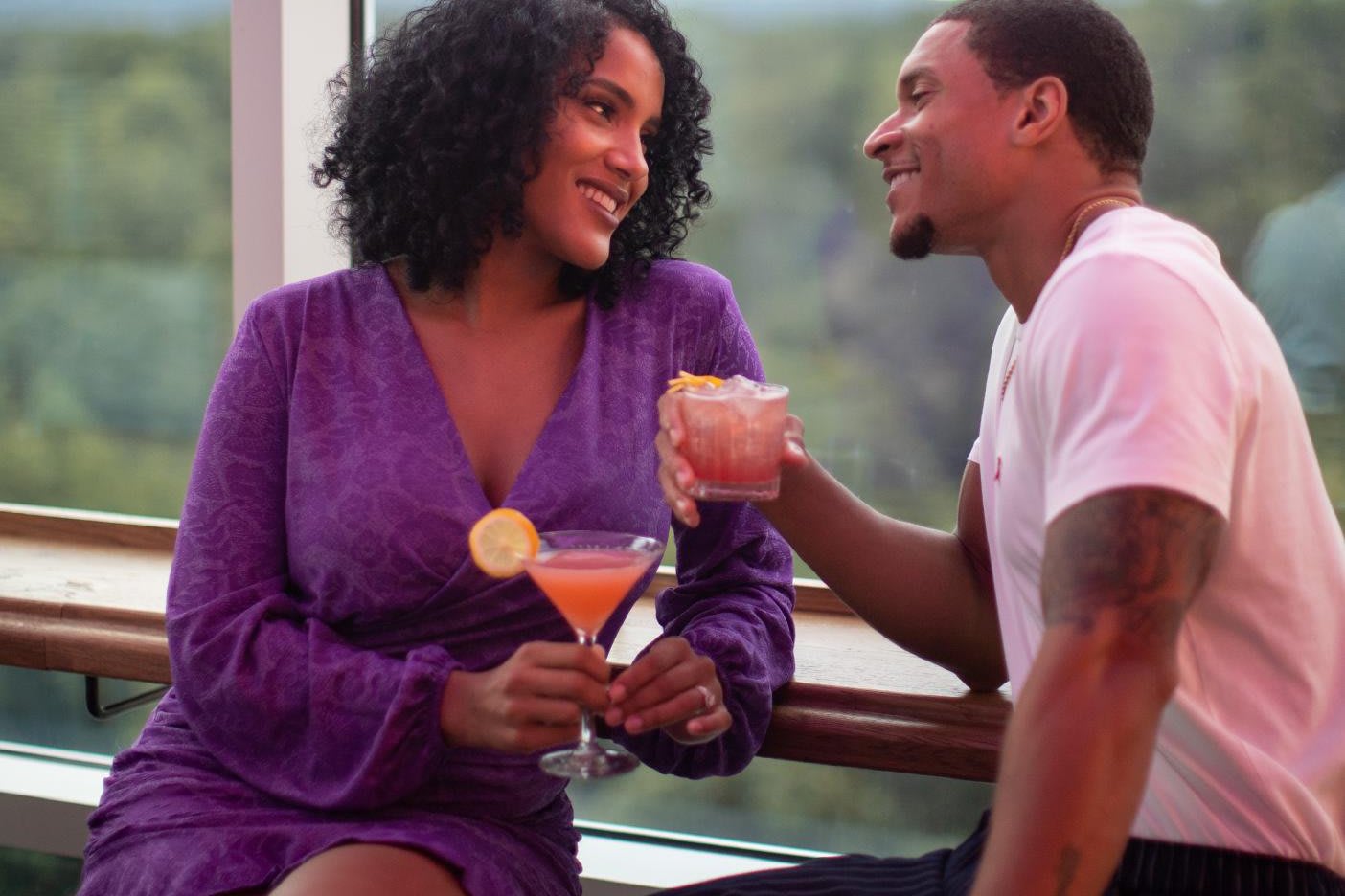 A couple enjoys cocktails together at a bar with a scenic view in Atlanta, Georgia.