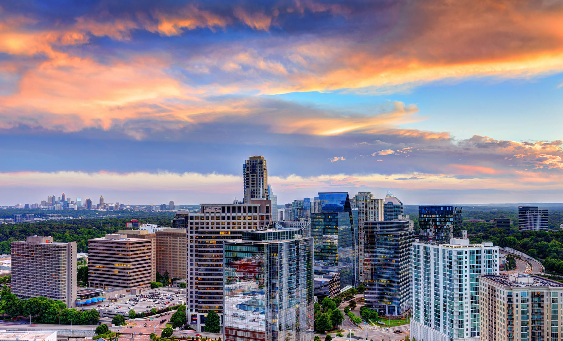 A vibrant city skyline at sunset with modern skyscrapers and a colorful sky in Atlanta, Georgia.