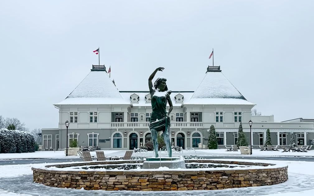 Snow-covered statue of a woman in a fountain, with a grand building in the background in Atlanta, Georgia.