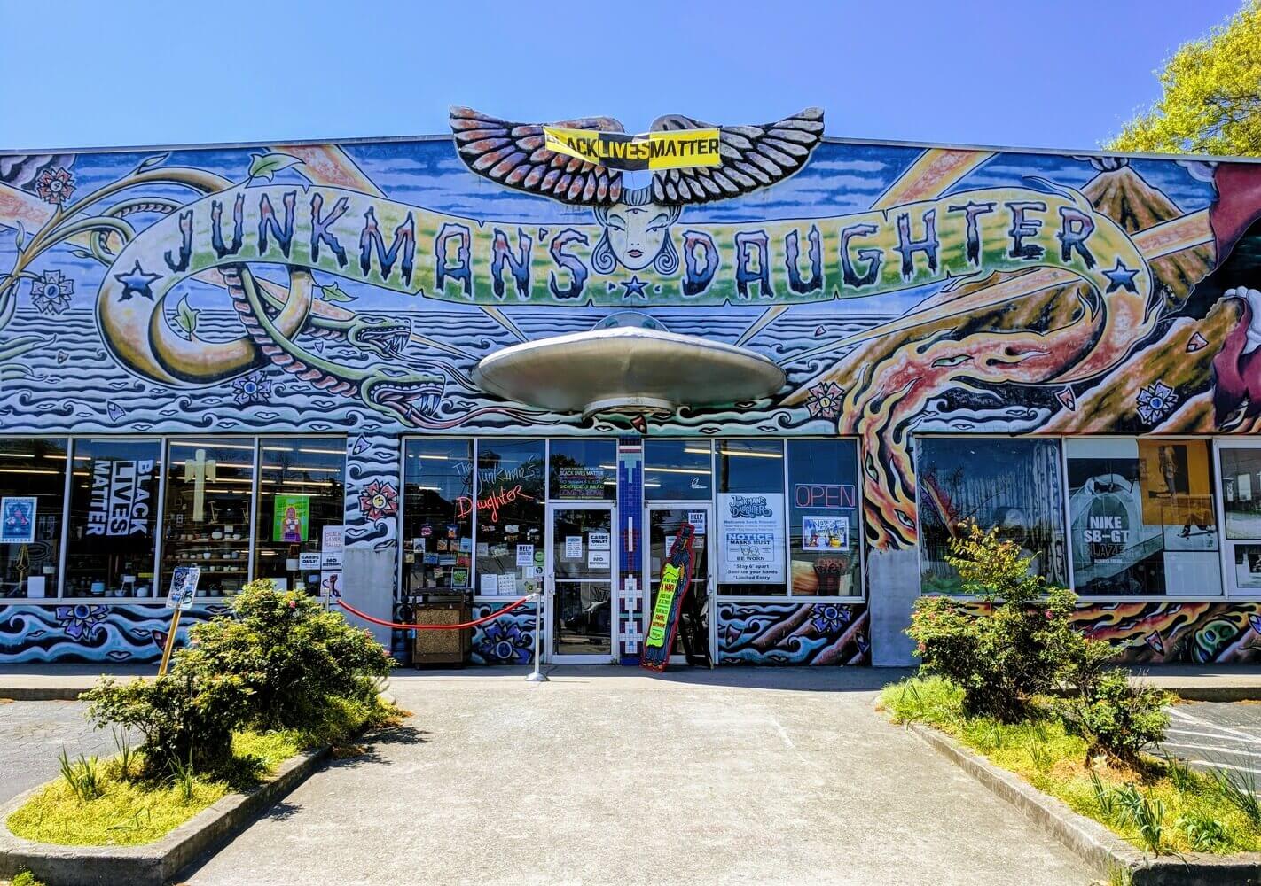 Colorful mural of a woman's face with wings and a snake, above a store entrance in Atlanta, Georgia.