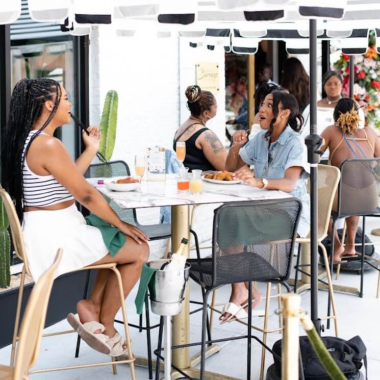 Four women enjoy a meal together at an outdoor restaurant table in Atlanta, Georgia.
